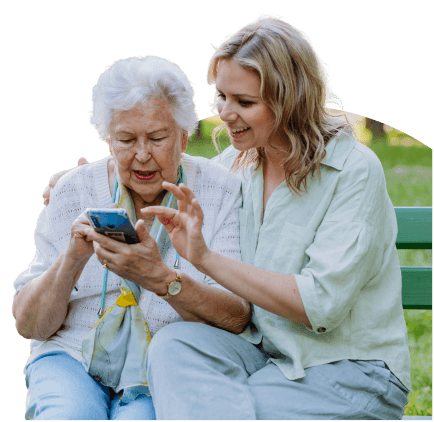 Two people sitting on a park bench looking at the myGP app on a phone